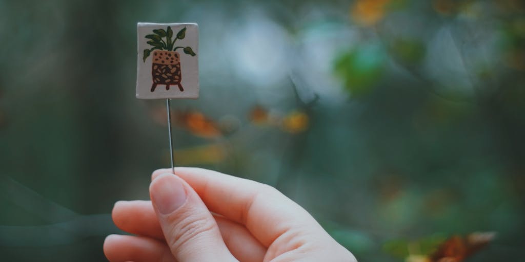 A conceptual photo featuring a hand holding a small, delicate object (like a dried flower, a feather, or a small key) against a blurred background. The object should be symbolic of a memory or event associated with the date. The focus should be sharp on the object and the hand, while the background should be out of focus, creating a sense of depth and mystery. The lighting should be dramatic, perhaps with a single light source casting shadows.