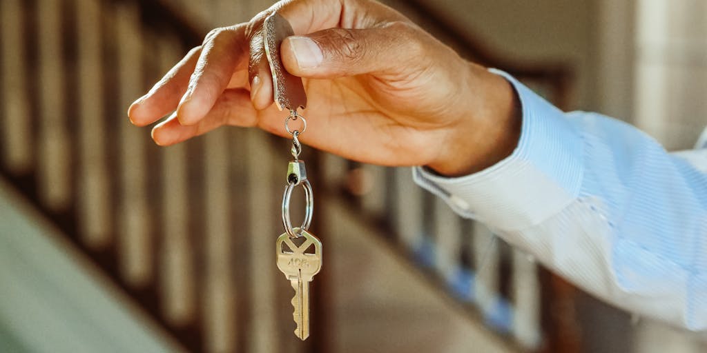 A close-up shot of a hand firmly placing a small, intricately designed key into a lock. The lock is slightly obscured, perhaps partially hidden behind a contract or legal document. The key represents the indemnitor's commitment and the lock symbolizes the protection being offered. The lighting should be dramatic, with a focus on the hand and key, creating a sense of responsibility and security. The background should be blurred to keep the focus on the action.