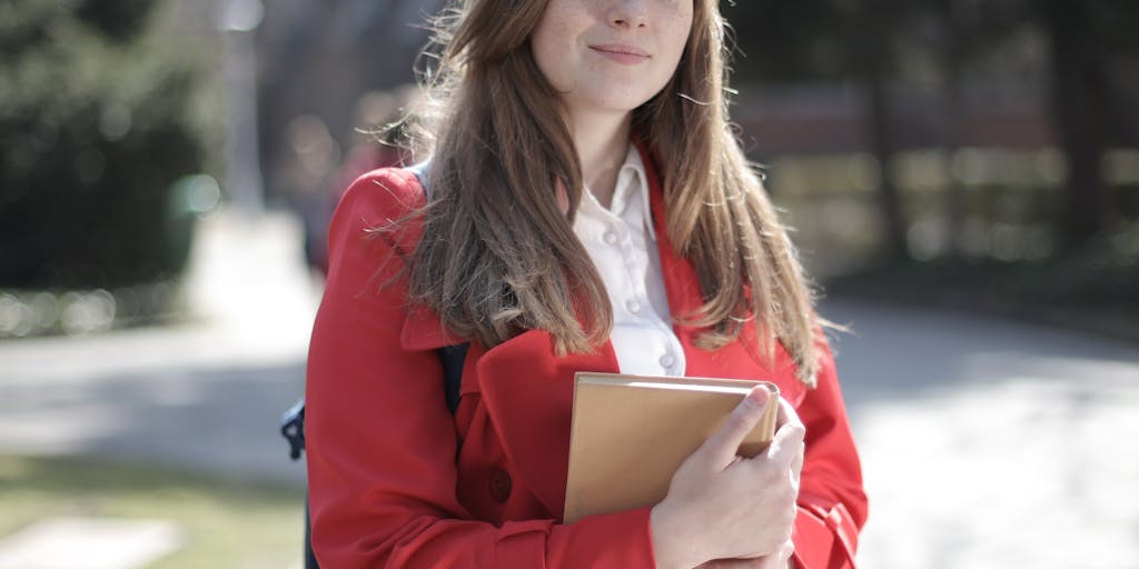 An artistic shot of a college student walking across campus with a backpack, holding a coffee cup in one hand and a document labeled 'Child Support Agreement' in the other. The campus is vibrant with autumn leaves, symbolizing change and growth, while the student looks determined and focused.