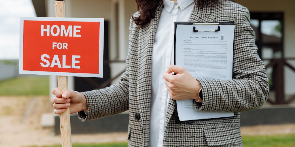 An image of a person holding a 'For Sale' sign in front of a damaged house, looking concerned. This visual represents the emotional impact of property damage and the importance of seeking legal help.