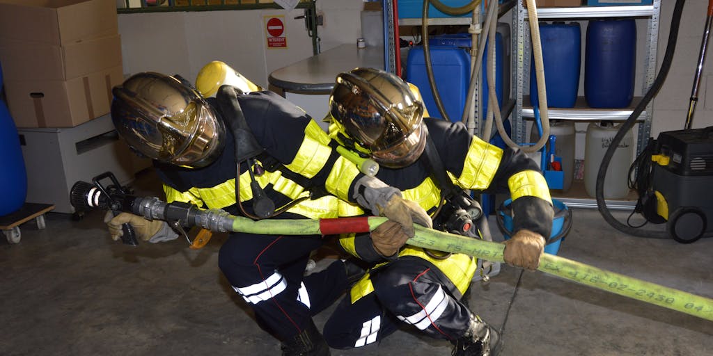 A photo capturing a team of warehouse employees conducting a safety drill, such as an emergency evacuation. They are seen practicing with fire extinguishers and following exit signs, showcasing preparedness and adherence to safety protocols.