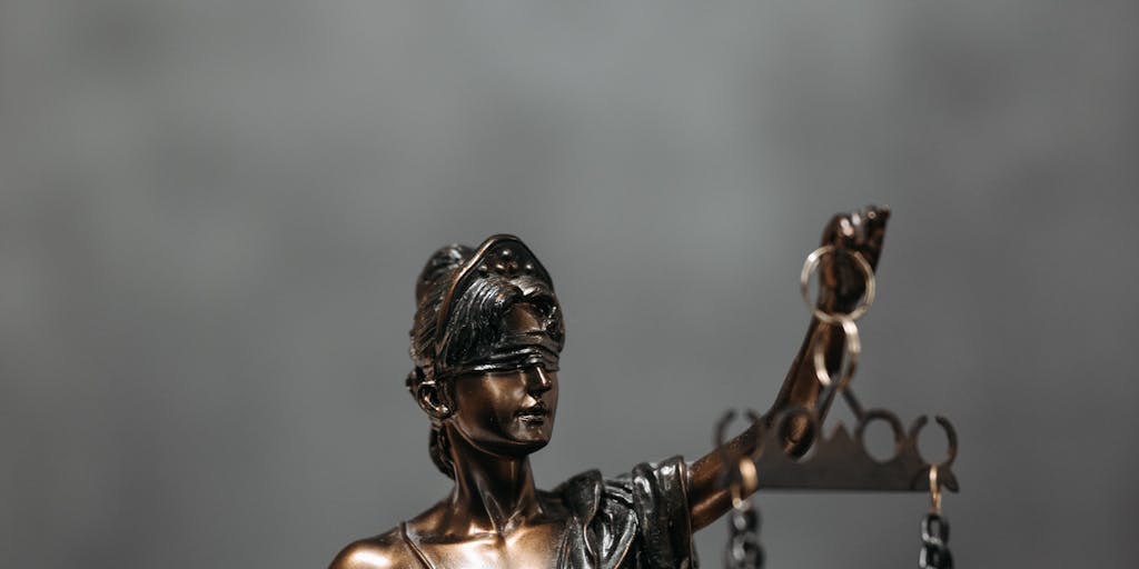 An artistic portrait of a top lawyer in Louisiana, dressed in a tailored suit, standing confidently in front of a historic courthouse. The image captures the essence of power and authority, with the courthouse's grand architecture in the background symbolizing justice.