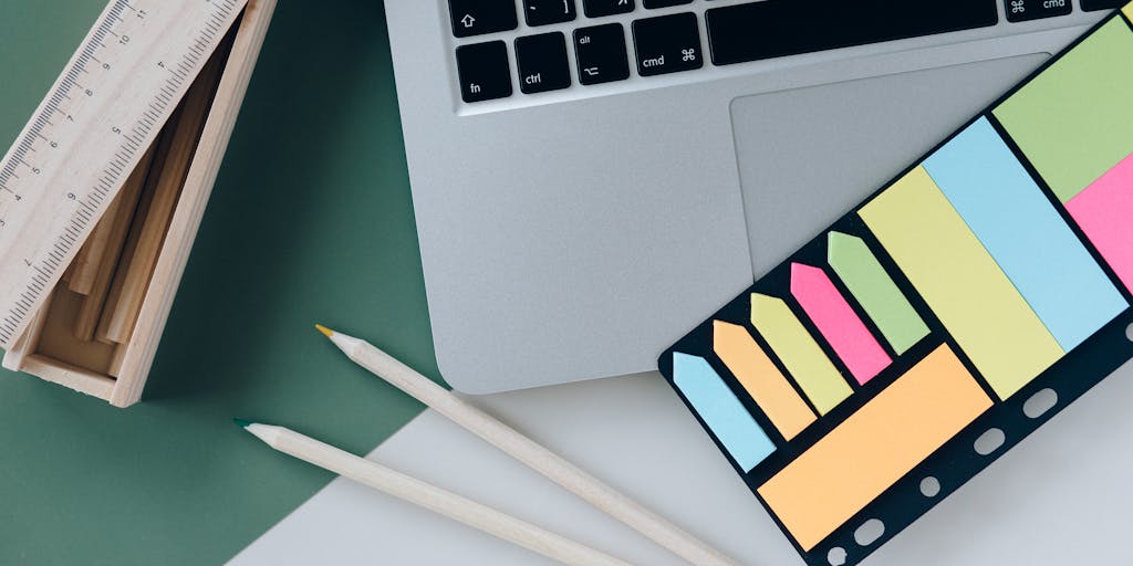 A creative flat lay of essential office supplies for lawyers, including a planner, a set of colored pens, a legal dictionary, and a coffee cup. The items are arranged on a wooden table with a soft light illuminating the scene, creating a warm and inviting atmosphere.