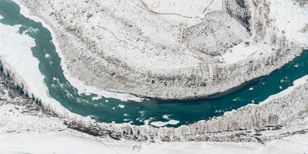 A serene landscape photo where a winding river forms the shape of a C note, with lush greenery on either side. The image captures the beauty of nature and the flow of water, symbolizing harmony and music.