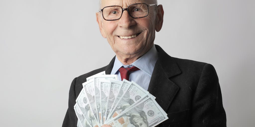 An artistic flat lay of various denominations of cash arranged in a circular pattern, surrounded by small items that represent financial goals, such as a miniature house, a car key, and a travel brochure. This composition conveys the idea of settled cash being the foundation for future aspirations.