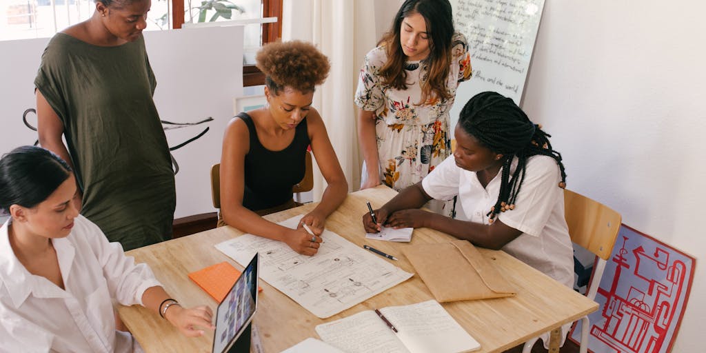 A diverse group of legal professionals gathered around a table, discussing a large digital tablet displaying AI-generated legal insights. The atmosphere is collaborative, with sticky notes and traditional legal books scattered around, highlighting the transition to digital tools in law.