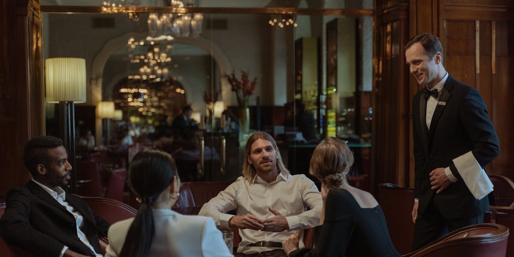 A group of well-dressed lawyers in a high-end restaurant, engaged in a lively discussion over dinner. The table is adorned with fine dining elements, and the ambiance reflects a networking event among the highest paid lawyers in Connecticut, showcasing their camaraderie and success.