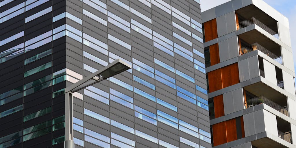 A dramatic shot of a high-rise office building in New Jersey, with a sleek, modern design. The building's glass facade reflects the skyline, symbolizing the success and prestige of the highest paid lawyers. In the foreground, a well-dressed lawyer is seen walking confidently towards the entrance, briefcase in hand, embodying ambition and professionalism.