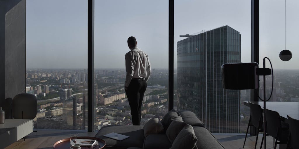 A dramatic overhead shot of a luxurious office space with a large mahogany desk, scattered legal documents, and a high-end laptop. The view includes a skyline of a major Australian city through a large window, symbolizing success and prestige in the legal profession.