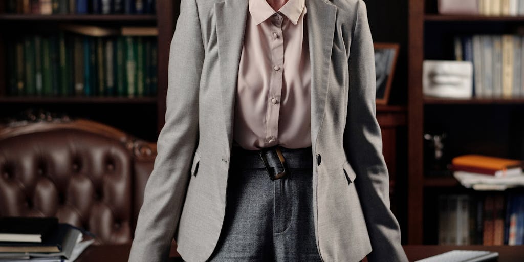 A close-up portrait of a confident lawyer in formal attire, standing in front of a historic courthouse in Austria. The lawyer should exude professionalism and authority, with a slight smile, showcasing the human side of high-paid legal professionals.