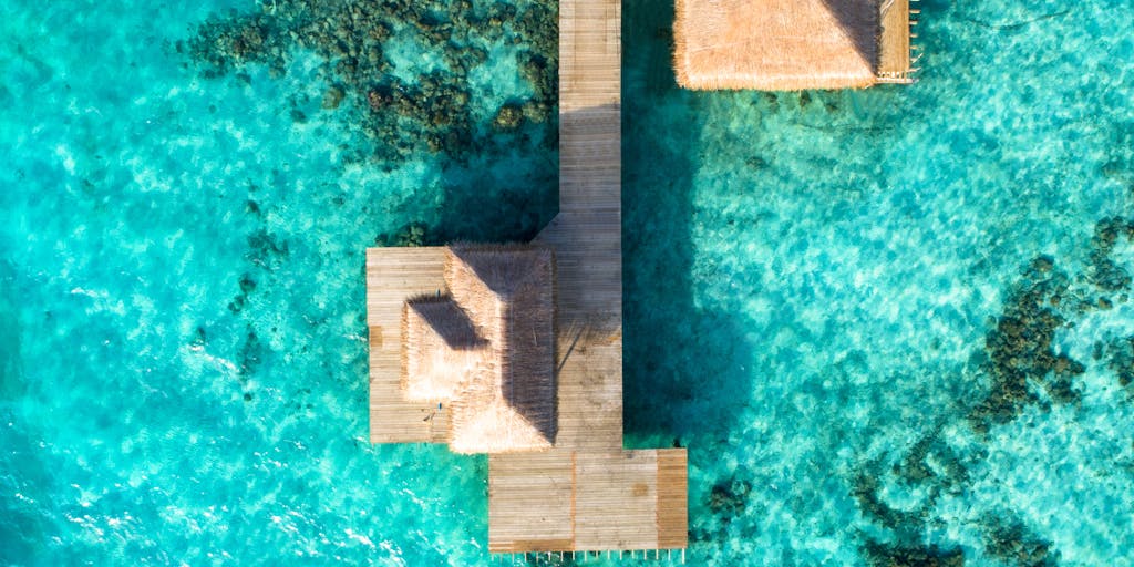 A dramatic aerial view of a Bahamian law firm building, showcasing its modern architecture surrounded by lush greenery and the ocean. The image conveys the idea of a prestigious legal practice thriving in a tropical paradise, emphasizing the allure of being a high-paid lawyer in the Bahamas.