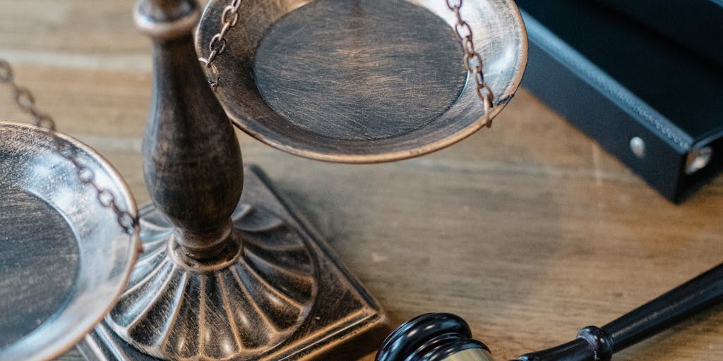 An artistic shot of a gavel and scales of justice placed on a stack of money, representing the financial success of top lawyers in Belarus. The background features a blurred image of a courthouse to emphasize the legal context.