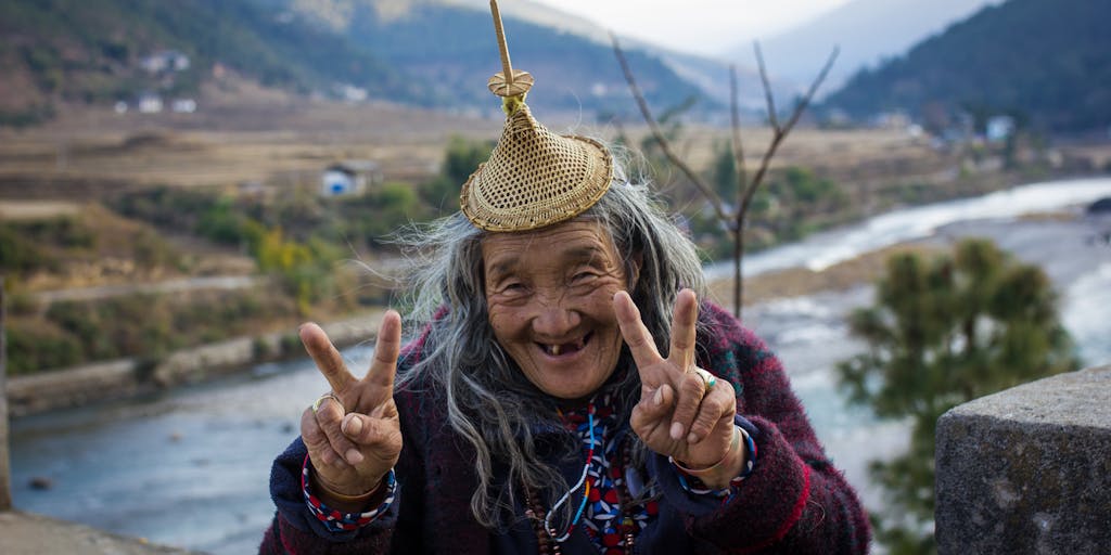 A dramatic portrait of a high-profile lawyer in Bhutan, dressed in traditional Bhutanese attire, standing confidently in front of the majestic Punakha Dzong. The lawyer holds a briefcase in one hand and a legal document in the other, symbolizing the blend of tradition and modernity in Bhutan's legal landscape.