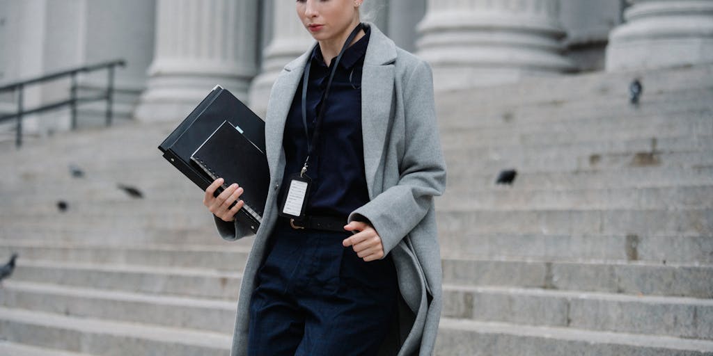 A creative composition showing a lawyer standing confidently on the steps of a courthouse, with a briefcase in one hand and a scale of justice in the other. The courthouse is adorned with Central African Republic flags, symbolizing the intersection of law and national pride.