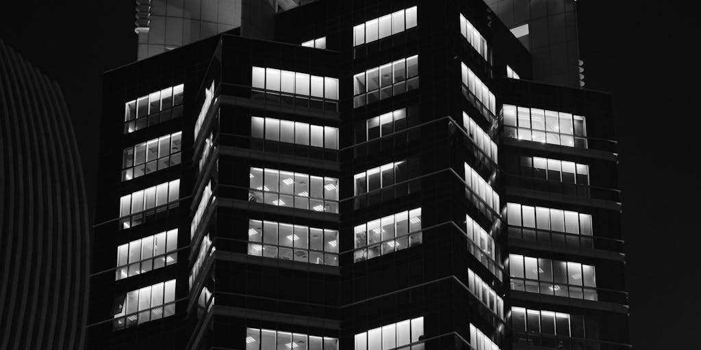 A dramatic overhead shot of a high-rise office building in a bustling city, symbolizing the power and prestige of the highest paid lawyers in China. The building's glass facade reflects the skyline, with a focus on the top floors where elite law firms are located. The image captures the essence of success and ambition in the legal profession.