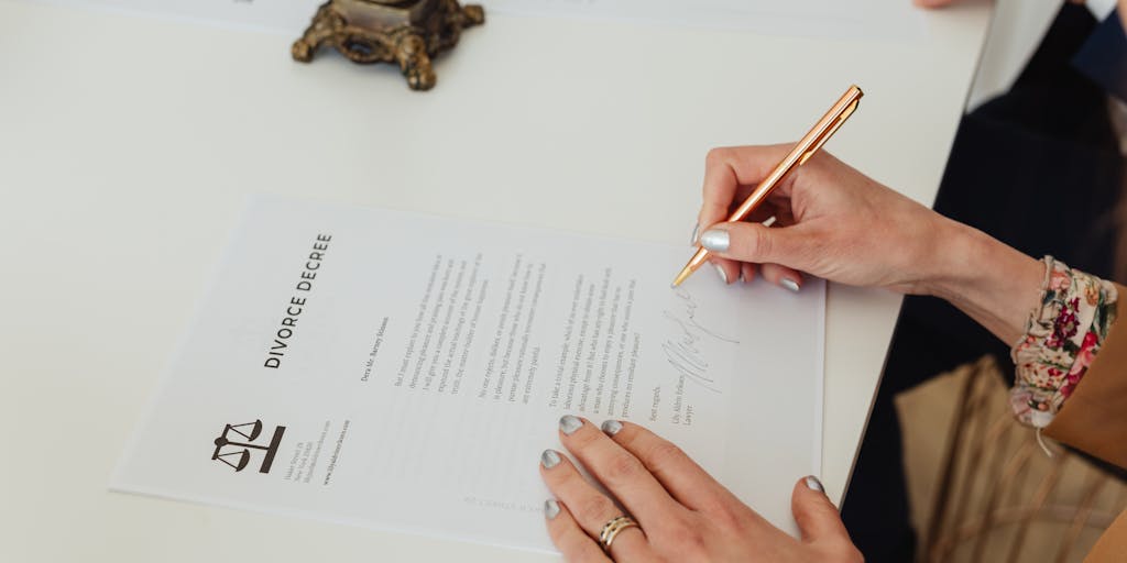 A close-up of a well-dressed lawyer's hand holding a golden pen poised over a high-profile legal document. The background features blurred images of iconic French landmarks like the Eiffel Tower and the Louvre, representing the intersection of law and culture in France.