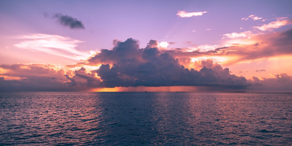 A close-up portrait of a high-profile lawyer in a tailored suit, standing confidently on a pristine beach with the sun setting in the background. The lawyer should be holding a briefcase, symbolizing the blend of work and paradise that characterizes the legal profession in the Maldives.