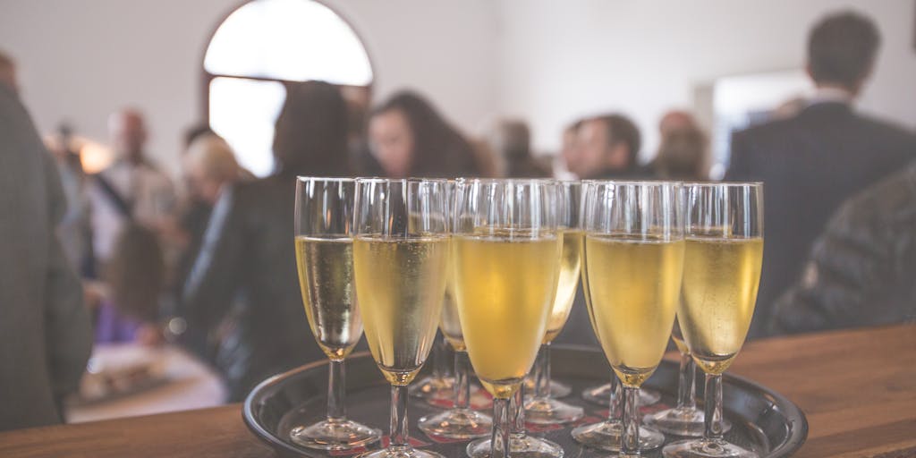 An overhead shot of a lavish dinner table set for a networking event, featuring high-profile lawyers discussing cases over gourmet food and fine wine. The ambiance is upscale, with elegant table settings and soft lighting, capturing the essence of high-stakes legal negotiations.