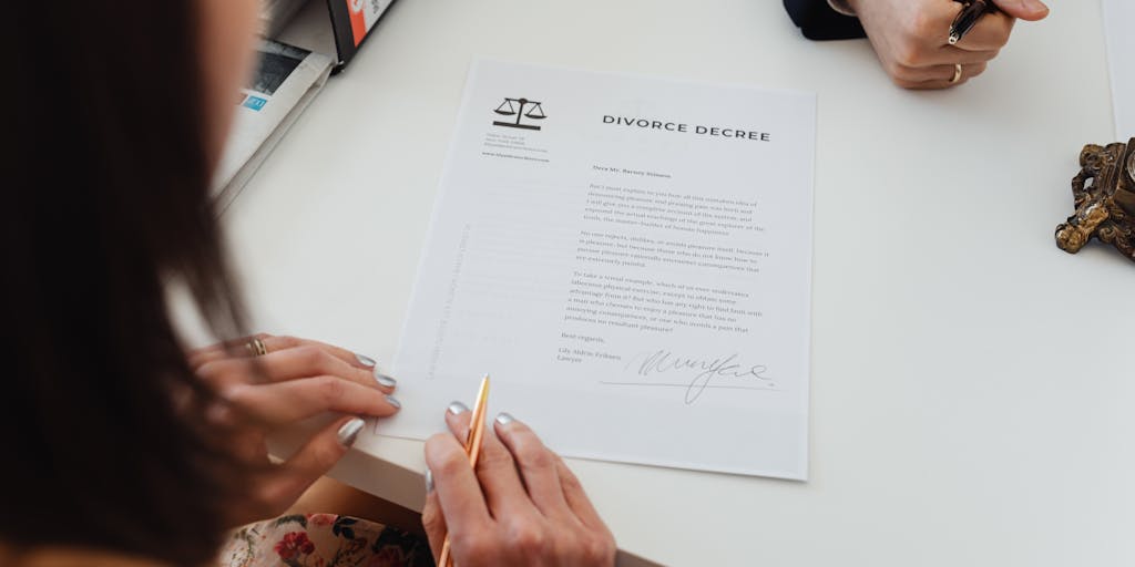 A close-up shot of a lawyer's hands signing a significant contract, with a backdrop of São Tomé's beautiful coastline visible through a window. This image symbolizes the importance of legal agreements and the high stakes involved in the work of top lawyers.