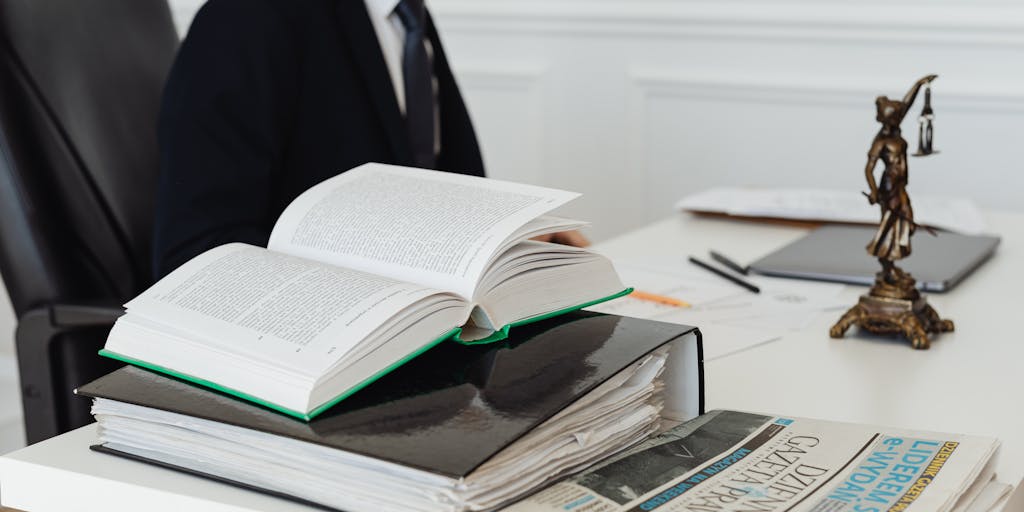 An artistic shot of a lawyer's briefcase overflowing with legal books and documents, set against a backdrop of iconic South African landmarks like Table Mountain or the Union Buildings. This image symbolizes the journey and dedication of top lawyers in the country.