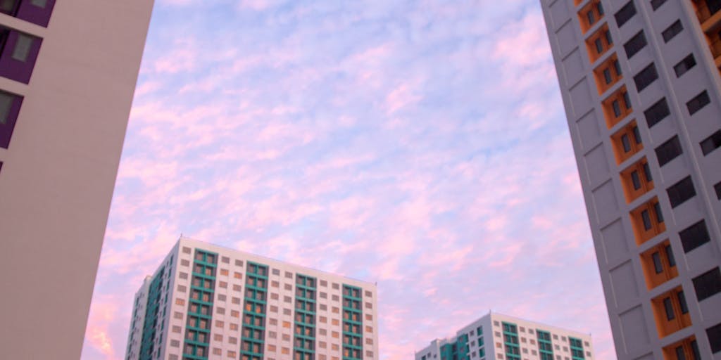 A dramatic shot of a high-rise office building in Vanuatu, with a lawyer in a sharp suit standing confidently in front of it, holding a briefcase. The sunset casts a golden hue, symbolizing success and ambition in the legal profession.