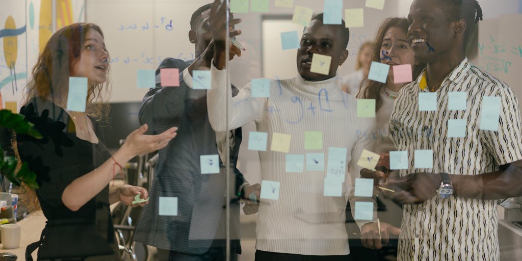 A dynamic photo of a group of diverse individuals engaged in a lively discussion, with one person enthusiastically explaining the concept of LLLP using a whiteboard. The energy of the group is palpable, showcasing collaboration and creativity.