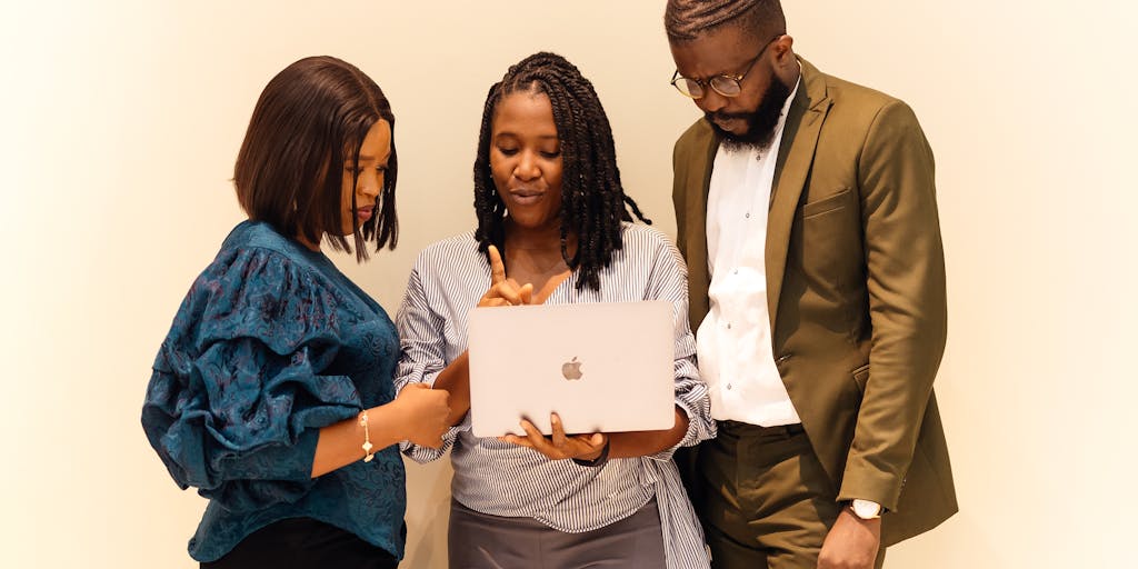 A dynamic shot of a diverse group of professionals engaged in a brainstorming session around a table, with a large 'Statement of Information' document projected on a screen behind them. The image captures collaboration and the sharing of ideas.