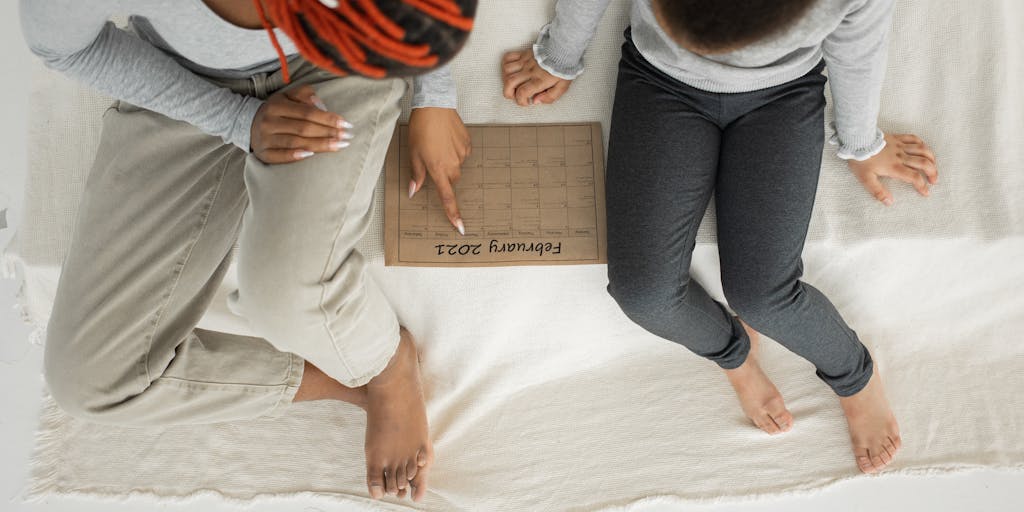 A candid shot of a parent and child engaging in a fun activity, such as baking or playing a game, with a visible calendar in the background marking child support payment dates. This image emphasizes the positive outcomes of child support on parent-child relationships.