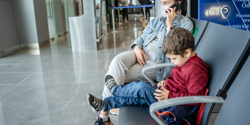 An artistic representation of a person standing at an airport gate, looking back with a heavy heart at a child holding a toy. The scene captures the bittersweet moment of wanting to travel but feeling the weight of child support obligations.