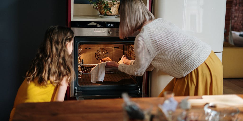 A heartwarming scene of a parent and child cooking together in the kitchen, with ingredients and a recipe book visible. This photo represents the emotional and nurturing aspects of child support, emphasizing the importance of shared experiences and daily care.