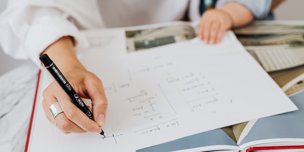 A creative flat lay of a calculator, a notepad with calculations for child support, and a toy or children's book. The notepad should have visible calculations showing how much child support would be based on a $500 weekly income, emphasizing the financial planning aspect.