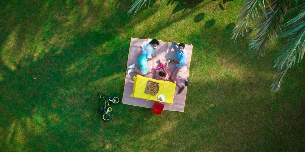A candid moment of a parent and child enjoying a day out at a park, with a picnic basket and toys in the foreground. The image captures the joy of spending quality time together, emphasizing how child support enables shared experiences.