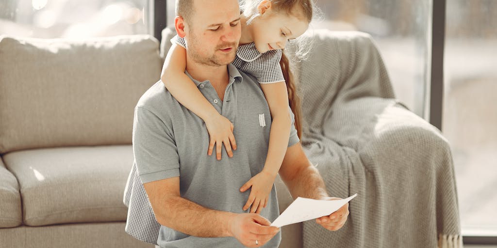 An emotional scene of a parent sitting at a kitchen table with a child, both looking at a document that outlines child support payments. The warm lighting and expressions convey the seriousness of the topic while emphasizing the bond between parent and child.