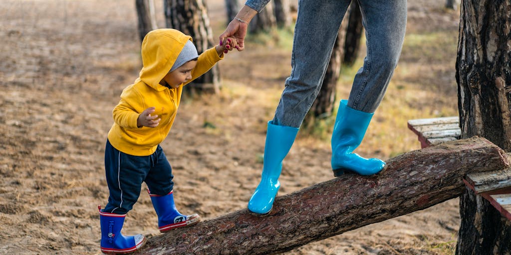 A close-up shot of a mother and child playing together in a park, with a subtle overlay of legal documents and a calculator in the background, symbolizing the balance between parenting and financial responsibilities.