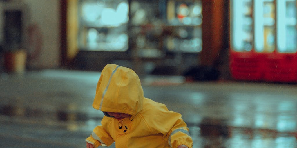 A whimsical illustration of a child holding a giant umbrella labeled 'Child Support' while standing in a rainstorm of bills and paperwork. The child looks cheerful and carefree, symbolizing the idea of avoiding the burdens of child support through creativity and humor.