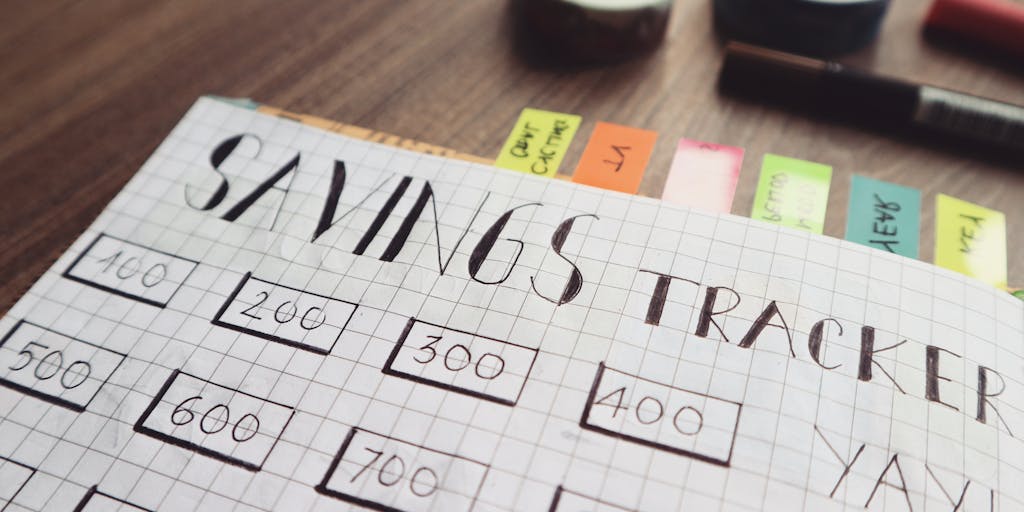 A creative flat lay of a weekly planner opened to a page with 'Child Support' written in bold, surrounded by items like a piggy bank, a toy, and a receipt. This setup conveys the planning and budgeting aspect of child support payments.