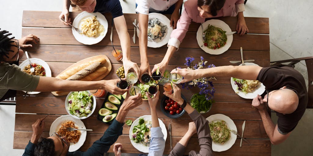 An overhead shot of a family dinner table with a child’s drawing of a house and family in the center, surrounded by tax forms and a calculator. This image symbolizes the connection between family support and financial responsibilities.