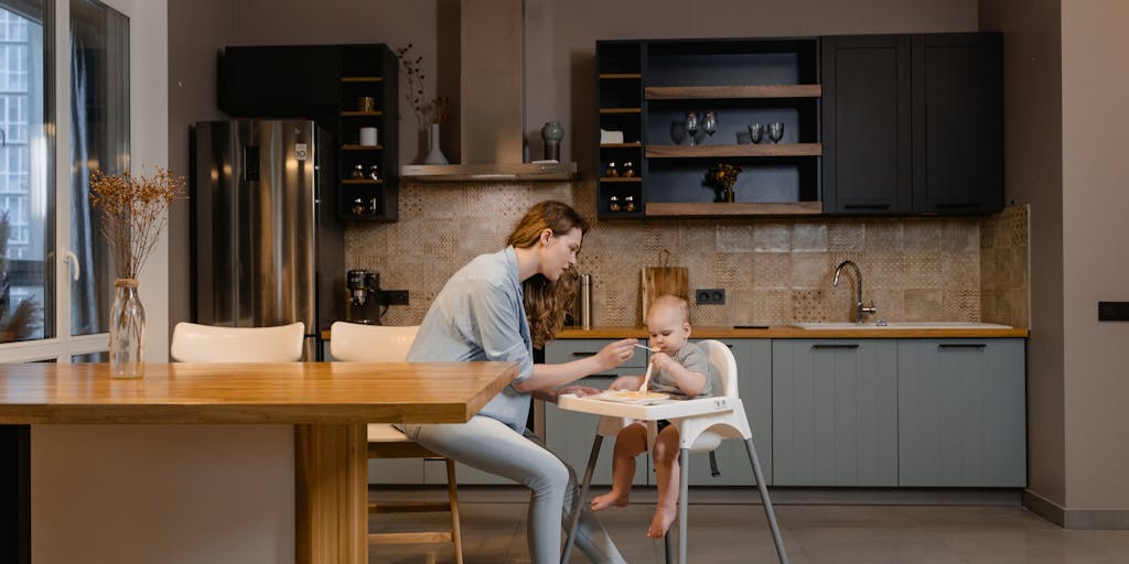 A candid moment of a parent and child sharing a meal at a dining table, with a visible empty chair across from them, symbolizing the absence of the other parent and the emotional aspect of child support.