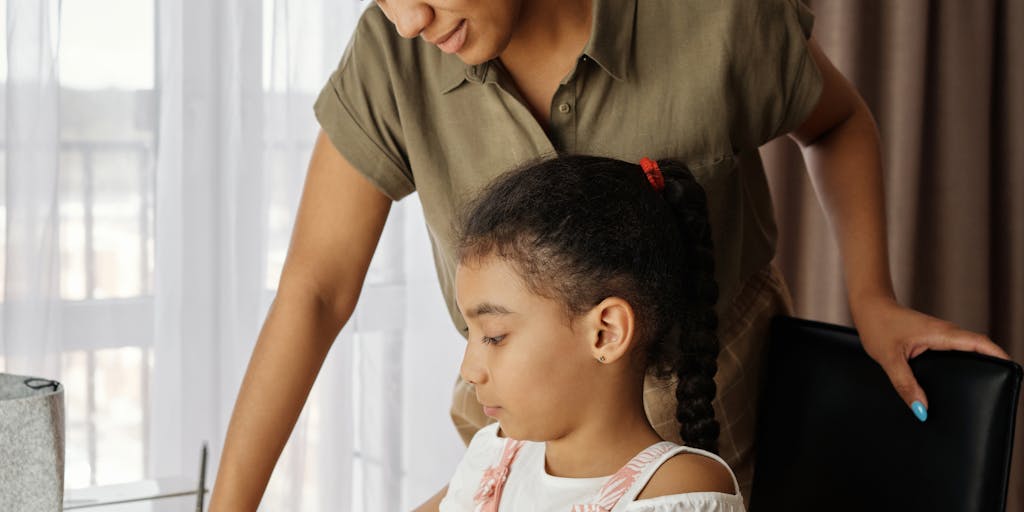 A close-up shot of a hand writing a check for child support, with a child's drawing or photo in the background. This image conveys the personal connection and responsibility that comes with financial support, highlighting the emotional aspect of providing for a child.