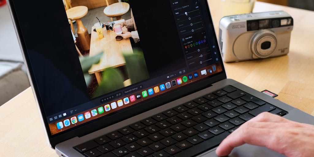 A close-up shot of a person using a laptop with the Rocketreach website open, showcasing the interface and features. The background should be a cozy workspace with plants and a coffee cup, emphasizing productivity and modern technology.