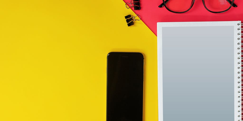A creative flat lay of various tools and gadgets used for digital marketing, including a smartphone displaying the Rocketreach app, notebooks, and a cup of coffee. The arrangement should be aesthetically pleasing, highlighting the theme of digital outreach.