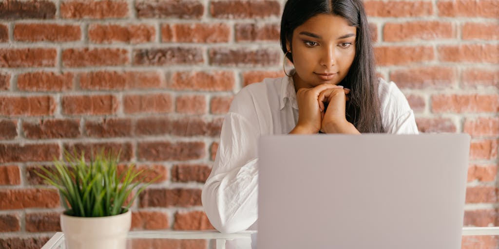 A split-screen image showing a person using a laptop on one side, with a vibrant, colorful interface of Instantly.ai on the screen, and on the other side, a close-up of their focused face, highlighting their engagement and satisfaction. The background should be a cozy home office setting.