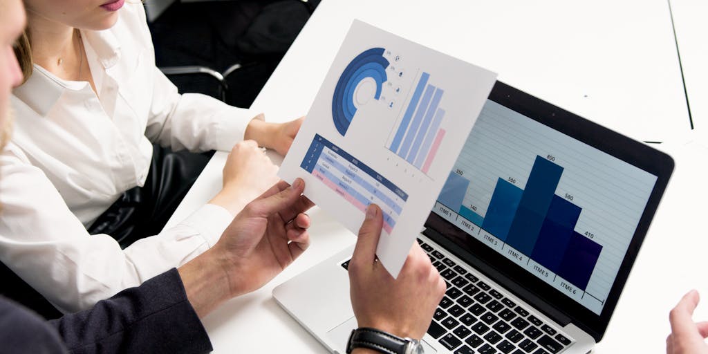 A dynamic image of a team meeting in a modern office, with a large screen displaying a LeadFuze presentation. Team members are actively discussing and pointing at the screen, showcasing collaboration and the impact of LeadFuze on their lead generation strategy.