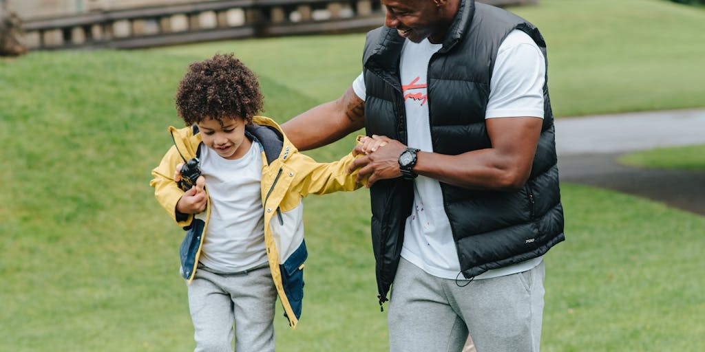 A serene image of a parent and child walking hand-in-hand in a park, with a soft focus on their faces, conveying a sense of peace and resolution after navigating the complexities of child support issues.