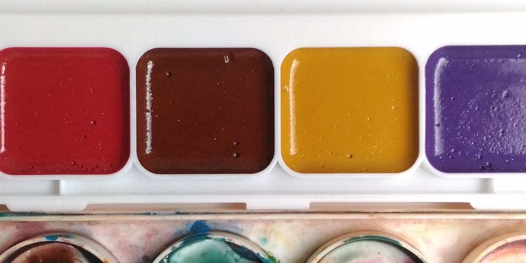 A close-up shot of a colorful, dripping paint palette, symbolizing the various pricing tiers of Dripify. Each color represents a different pricing plan, with the paint dripping down onto a canvas that has the Dripify logo subtly integrated into the design.