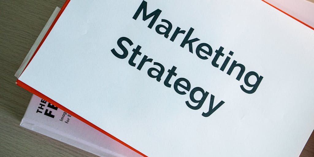 An overhead view of a desk cluttered with various marketing materials, including brochures and charts that highlight Outreach IO pricing. A laptop is open with a graph showing growth, symbolizing the impact of effective pricing strategies.