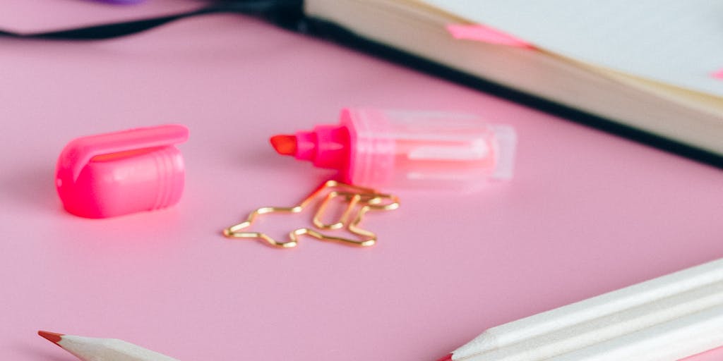 A creative flat lay featuring a calculator, a notepad with handwritten notes about Mailshake pricing, and colorful sticky notes. The image should represent the analytical side of choosing a pricing plan, with a vibrant and engaging color palette.