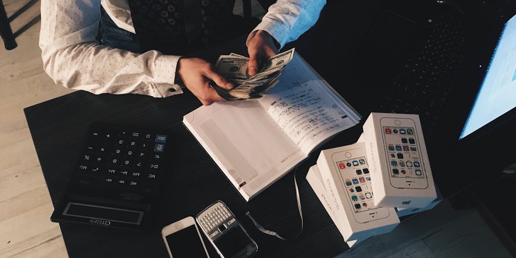 An overhead view of a desk with a laptop open to the Evaboot pricing page, alongside a calculator, a notepad with pricing strategies, and a cup of coffee. The scene is well-lit, emphasizing the focus on financial planning and decision-making.