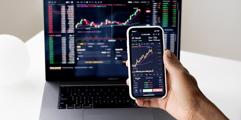 A close-up shot of a smartphone displaying a colorful graph or chart representing pricing tiers for outreach voice services. The background features a blurred office setting, suggesting a professional environment. The focus is on the screen, highlighting the data visualization.