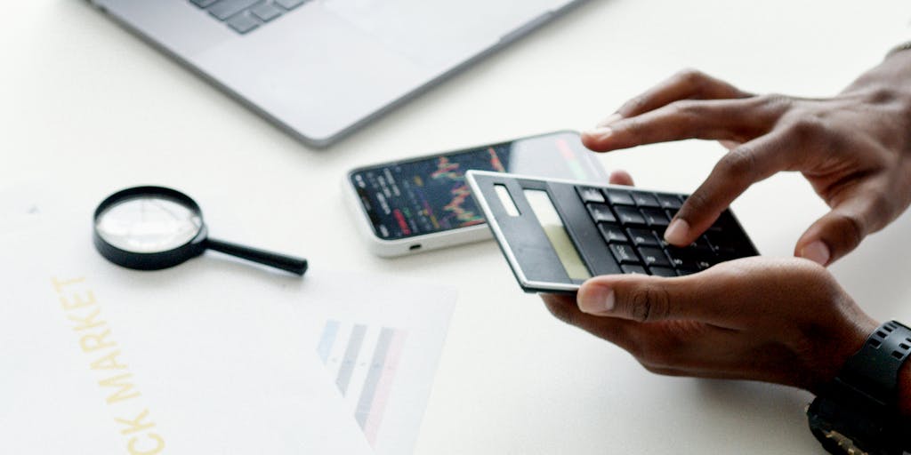 A close-up shot of a hand holding a magnifying glass over a pricing chart, emphasizing the details and nuances of pricing strategies. The background should be blurred to keep the focus on the magnifying glass and the chart, symbolizing the importance of analyzing pricing.